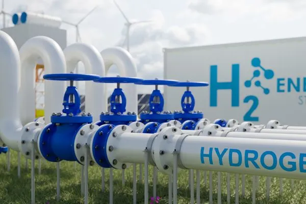 Pipes labeled "Hydrogen" lead to an energy storage facility, with wind turbines and storage tanks in the background.